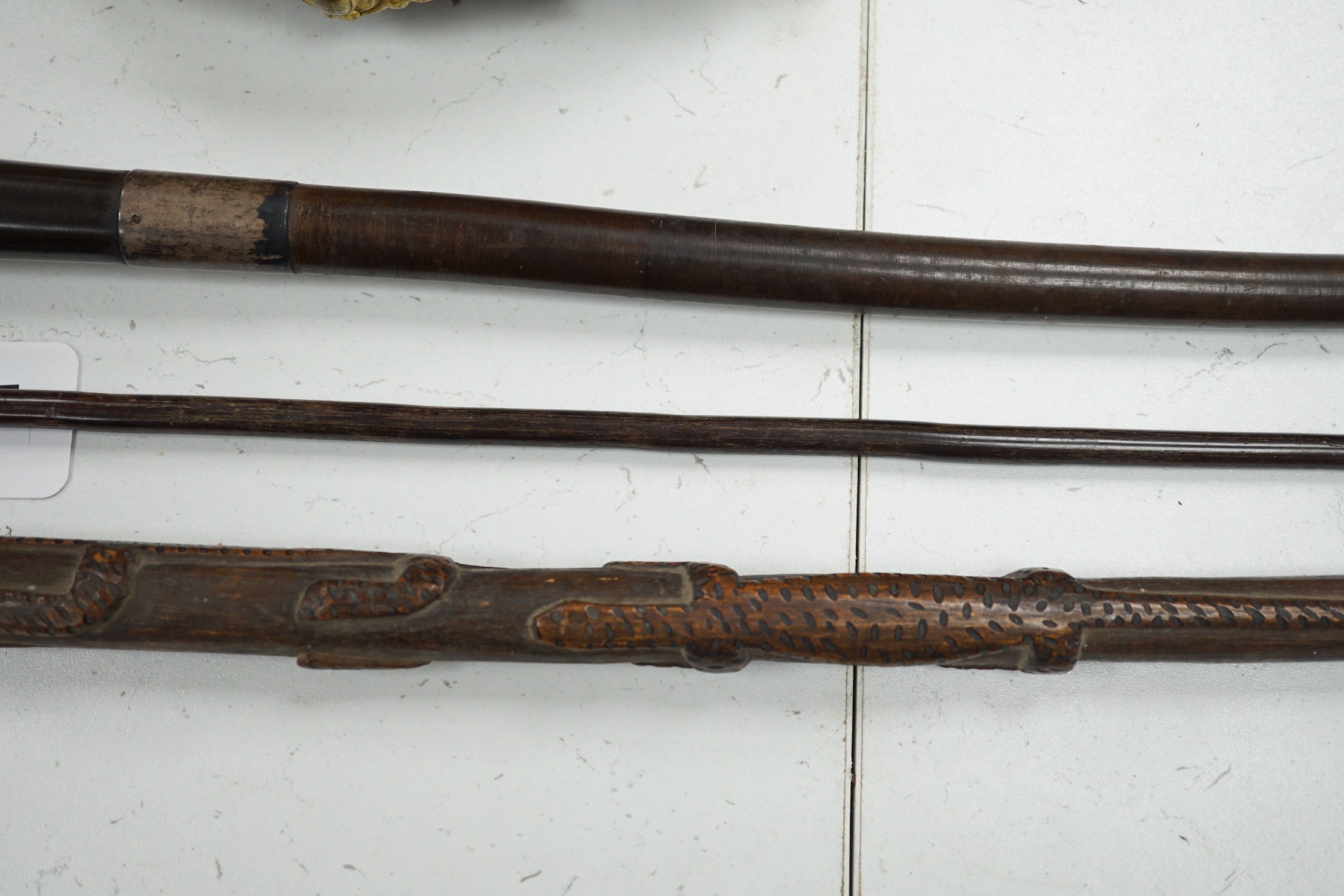 A bull's pizzle walking stick and two other carved wood sticks, largest 93cm